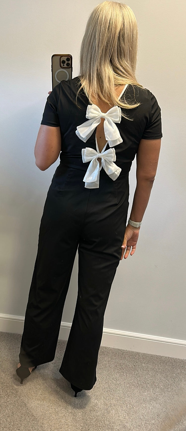 Black jumpsuit with bow detail on back one side would fit upto size 14