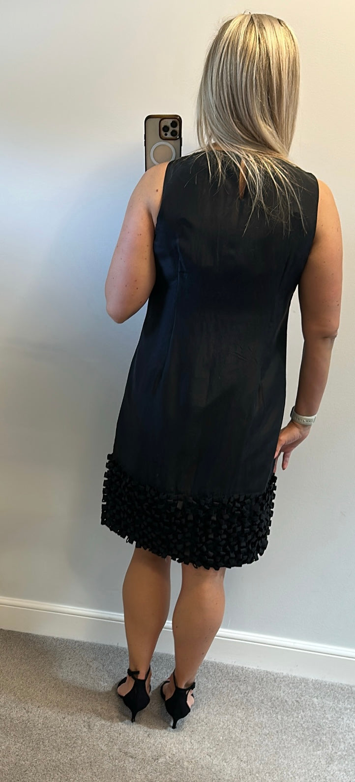 Yera black sleeveless dress with a textured ruffled hemline would fit upto size 14
