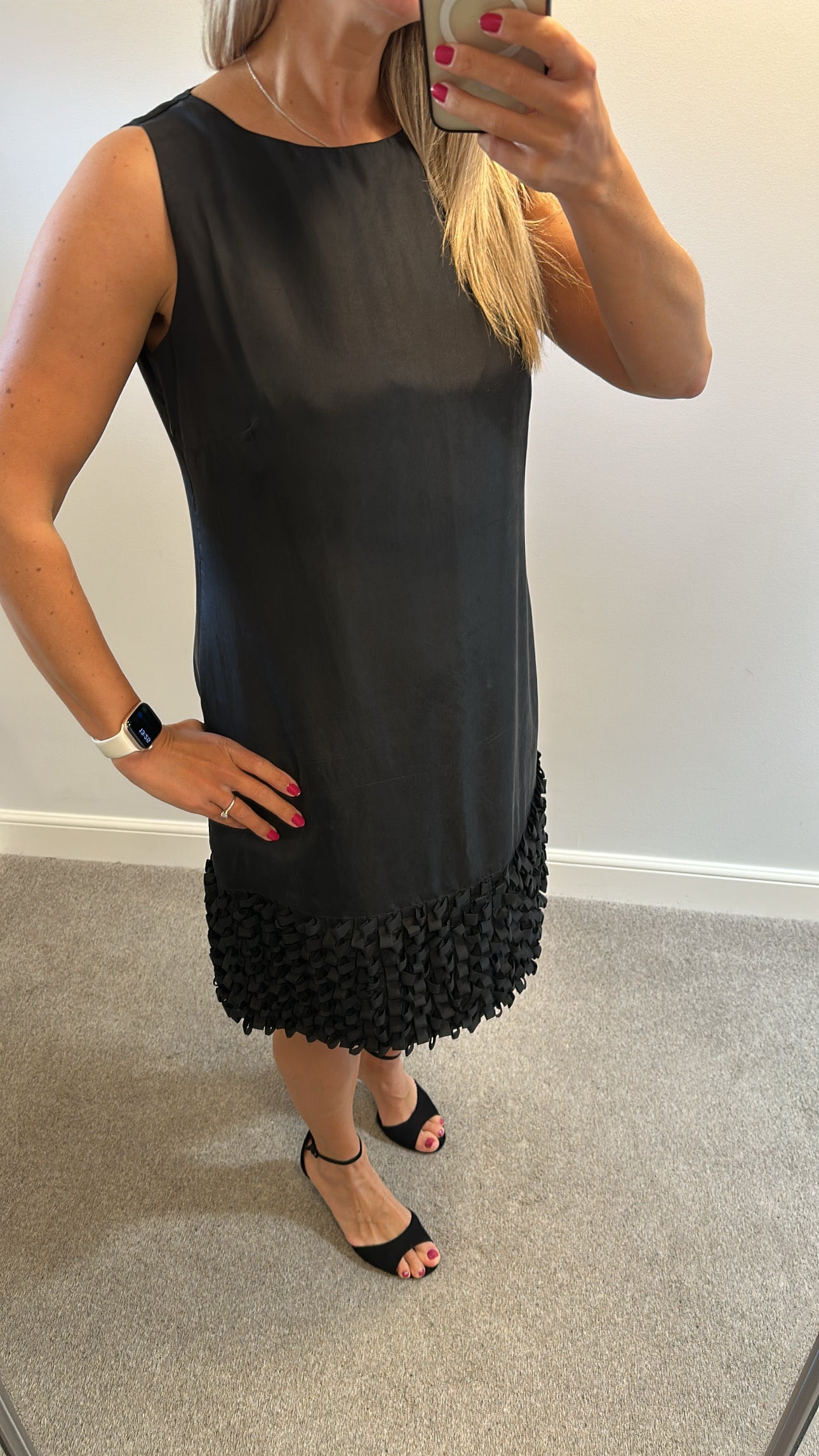Yera black sleeveless dress with a textured ruffled hemline would fit upto size 14