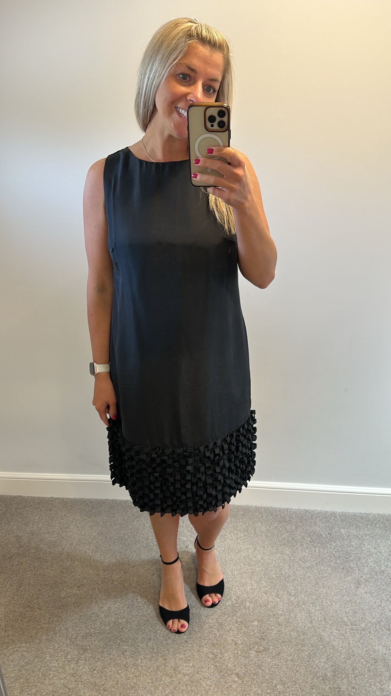 Yera black sleeveless dress with a textured ruffled hemline would fit upto size 14